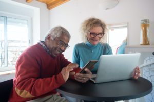 man and woman looking at screens