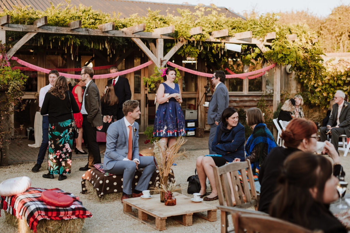 Fison barn courtyard decorated for a wedding celebration with colourful bunting streamers, hay bale chairs and throws